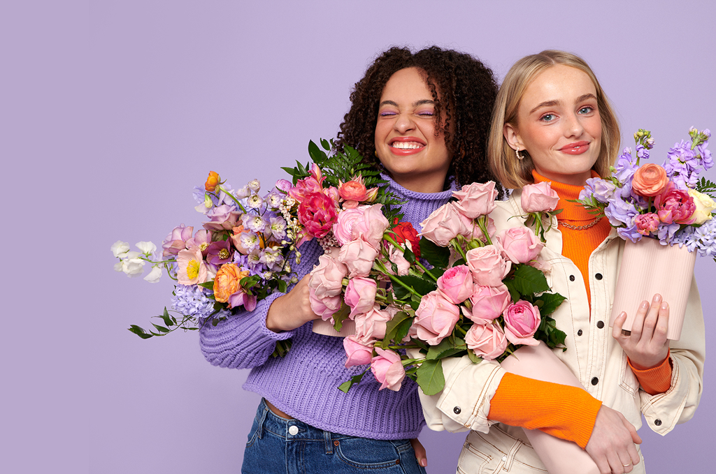 Two women smiling and holding DAILYBlooms flowers